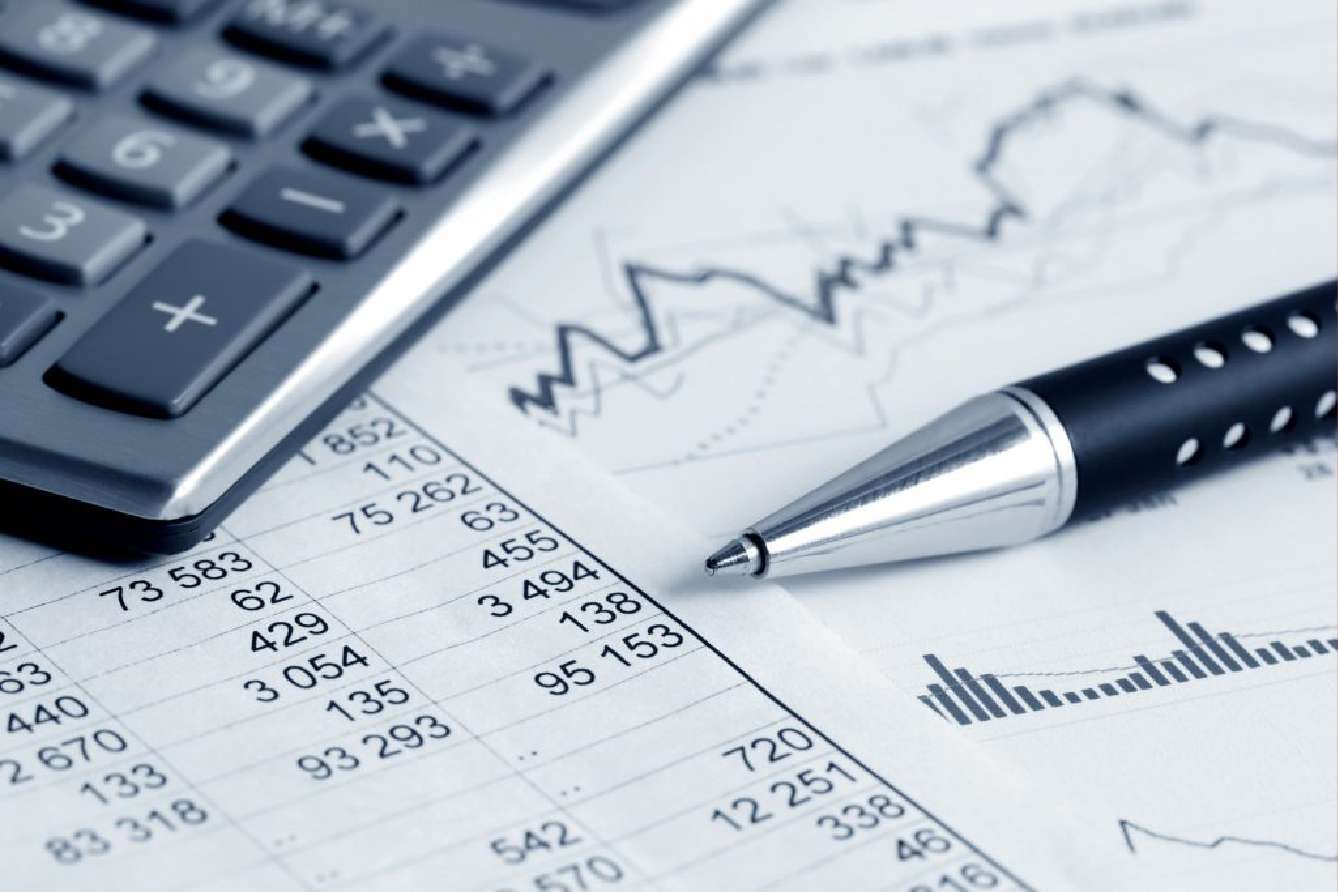 Reviewing school financial reports and budget data with a calculator and pen