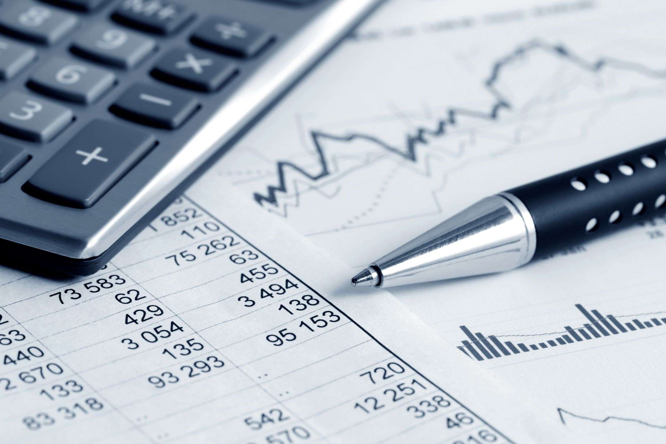 Financial spreadsheet with calculator and pen.