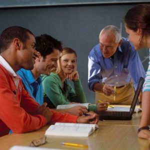 Educators and adult learners receiving support in a classroom
