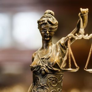 Close-up of a bronze statue of Lady Justice with scales.