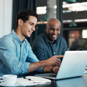 Teamwork, diversity and sales manager planning branding ideas with a creative designer on a laptop in an office. Logo, collaboration and businessman talking to an employee about a development project