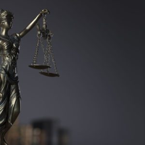 Themis , scale and legal books. Gray background.