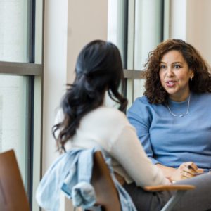 The female supervisor meets with her mid adult female employee to mentor her regarding a new position she is interested in within the company.