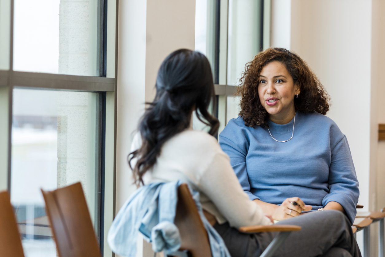 The female supervisor meets with her mid adult female employee to mentor her regarding a new position she is interested in within the company.