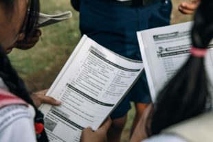 Students reviewing curriculum materials or taking an assessment, representing academic programs